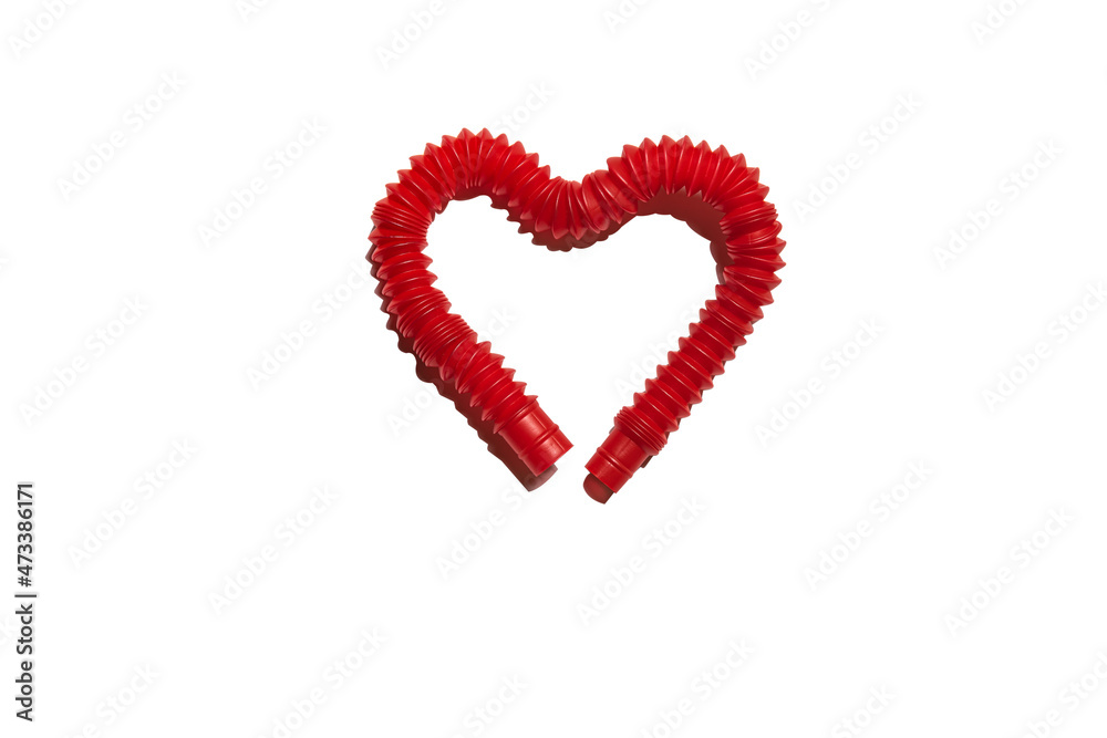 Red pop tube toy bent in shape of heart isolated on white