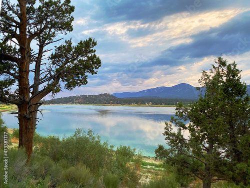 mountain lake with overcast blue sky and reflective shoreline scene