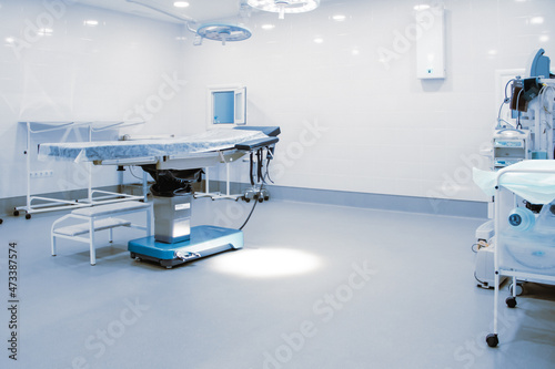 Fototapeta Naklejka Na Ścianę i Meble -  Empty interior operating room and modern equipment in hospital. Medical device for surgeon surgical emergency patient in blue tone style. Save life medical treatment concept
