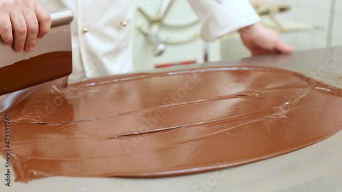 Pastry chef at work tempering chocolate in a restaurant kitchen