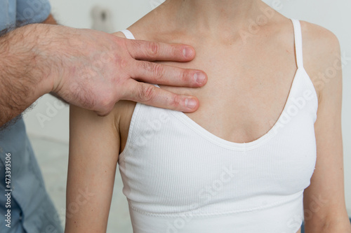 Wallpaper Mural Female patient receiving osteopathic neck and shoulder treatment. Therapist manipulating back of head and chest. A girl receiving CST treatment. Osteopathic manipulation and therapy Torontodigital.ca