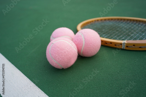 Tennis balls and rackets on tennis court.