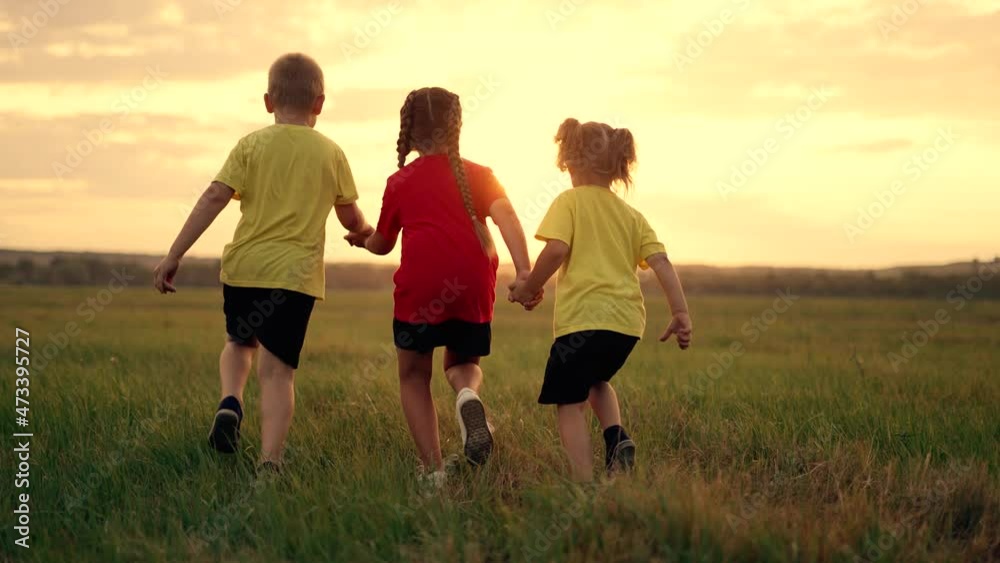Happy family on green grass. Child run through meadow in park. Healthy lifestyle concept. Silhouette of group of people in field in nature. Boy and girl run play outdoors in park. Happy family concept Happy family on green grass. Child run through meadow in park. Healthy lifestyle concept. Silhouette of group of people in field in nature. Boy and girl run play outdoors in park. Happy family concept