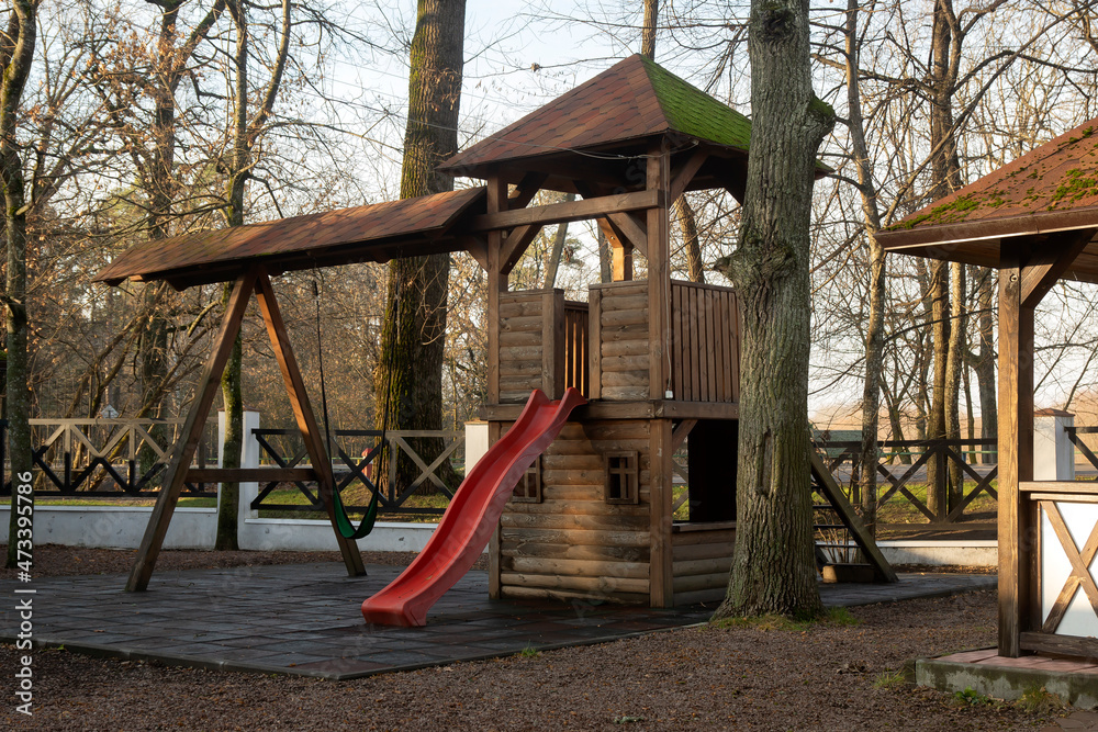 Wooden playground with a slide outside the city on an autumn morning. Wooden playground with a slide outside the city on an autumn morning.