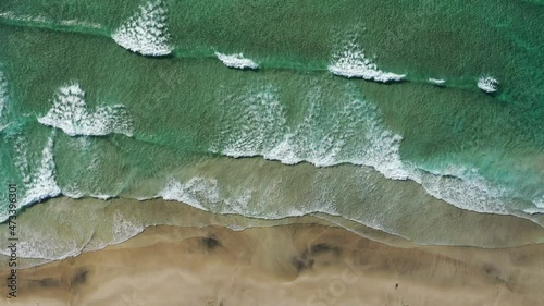 top down View on the sand Beach with Splashing Sea Waves photo