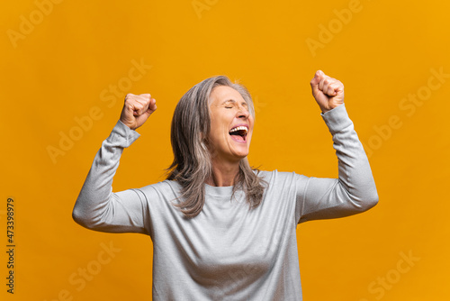Konstfotografi Overjoyed excited modern mature woman celebrating goal achievement, raising fist