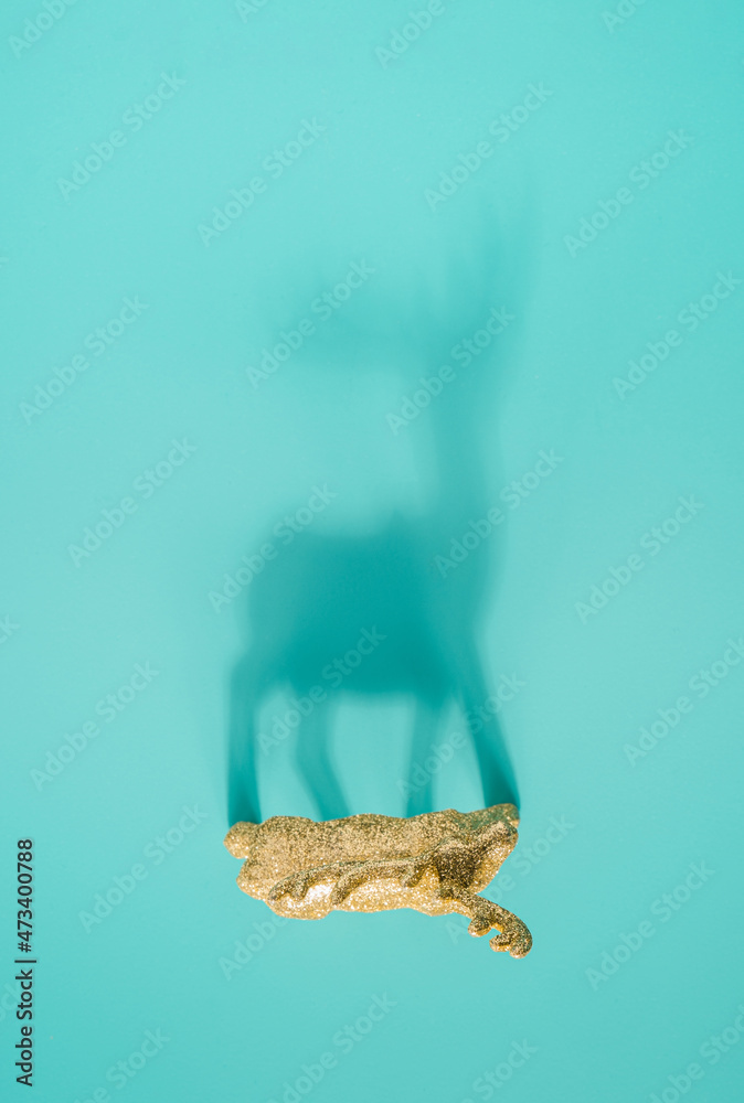 Reindeer ornament shadow on a light turquoise background. Minimal Christmas concept