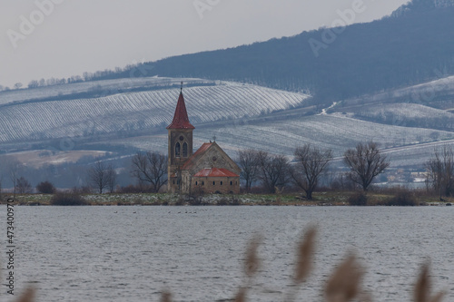 Lake Musov with the Church of St. Linharta in the Czech Republic in Europe. There is a reed around. Winter landscape and Palava. photo