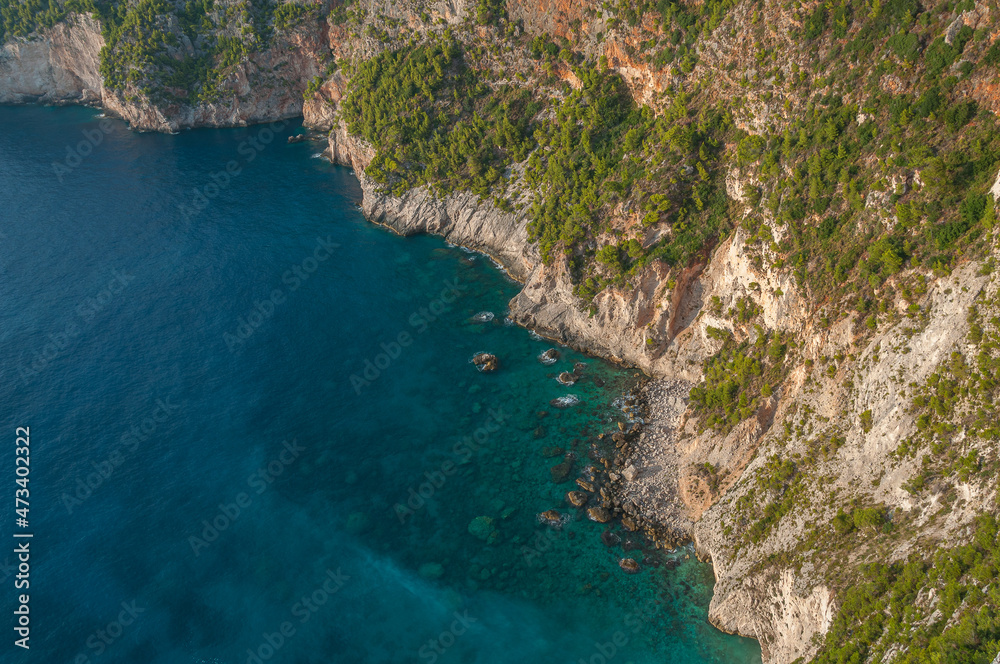 Top view of turquoise sea at the foot of cliffs in the rocky coast of Zakynthos island, Greece