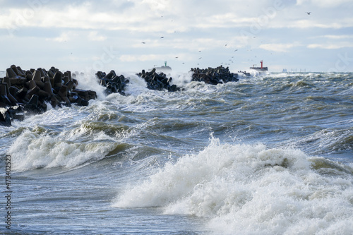 coastal storm in the baltic sea, big waves crash against the harbor breakwater