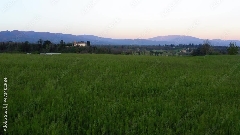 Aerial: Residential Houses Amidst Green Trees Against Clear Sky, Drone Flying Over Grass During Sunset - Apennine Mountains, Italy