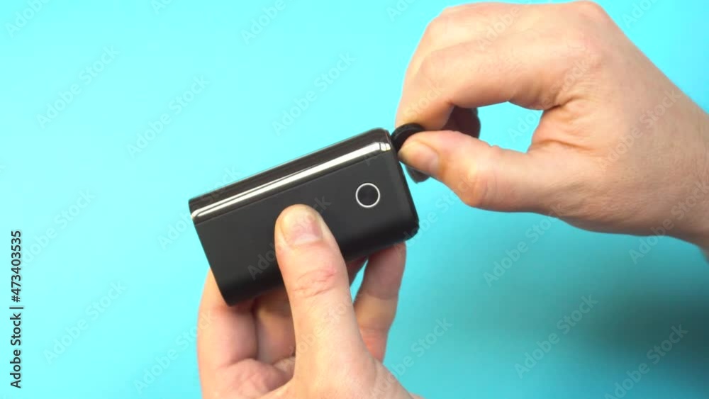 A device for heating tobacco, cleaning it with a brush.Device for smoking tobacco in male hands. A device for heating tobacco, cleaning it with a brush.Device for smoking tobacco in male hands.