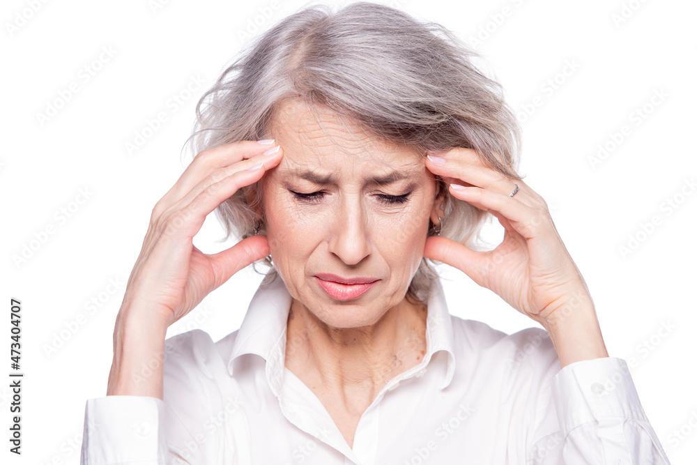 Portrait of an old but modern trendy woman suffering from a headache or migraine holding her head in her hands with a desperate expression and screaming from pain isolated on white background Portrait of an old but modern trendy woman suffering from a headache or migraine holding her head in her hands with a desperate expression and screaming from pain isolated on white background