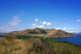 a hill surrounded by the water of Lake Sevan in Armenia in summer in sunny weather