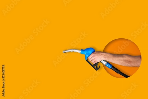 Car refueling gun on yellow background. Gas station with diesel and gasoline fuel