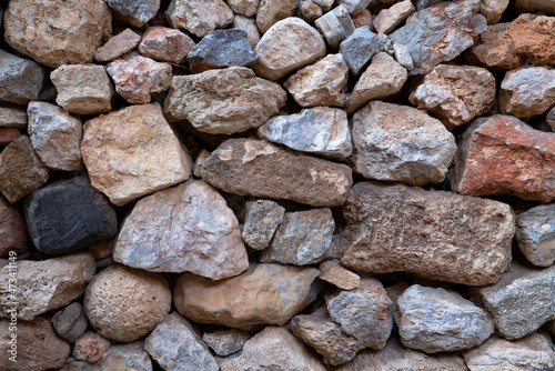 Textured background of masonry wall made of natural multicolored stones. Close-up
