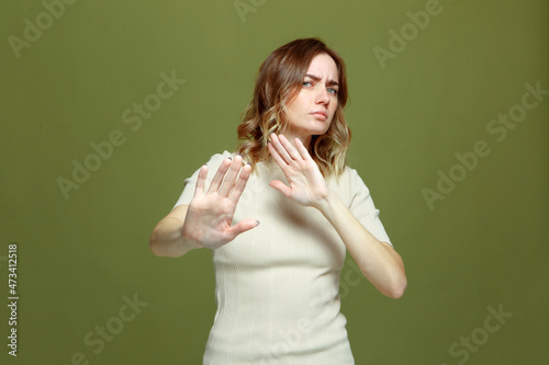 Displeased serious girl showing stop gesture, warning of finish, declining communication. Body language