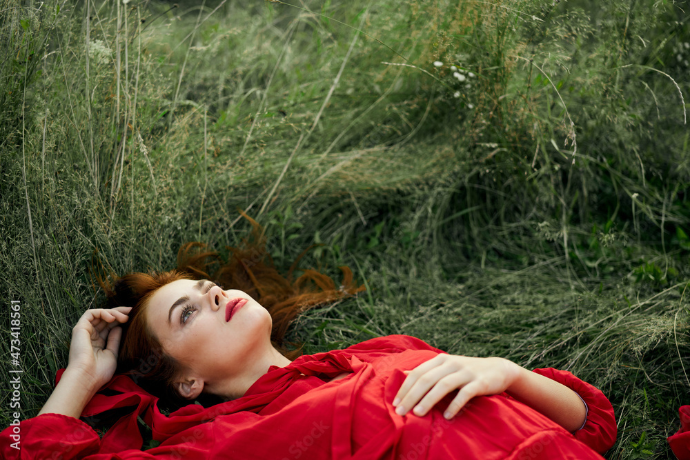 pretty woman in red dress lies on the grass freedom landscape pretty woman in red dress lies on the grass freedom landscape