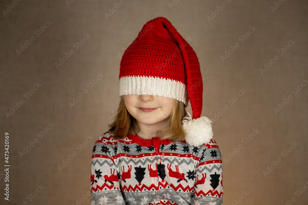 girl in santa hat and New Year's pajamas on a solid background. hat closes eyes girl in santa hat and New Year's pajamas on a solid background. hat closes eyes