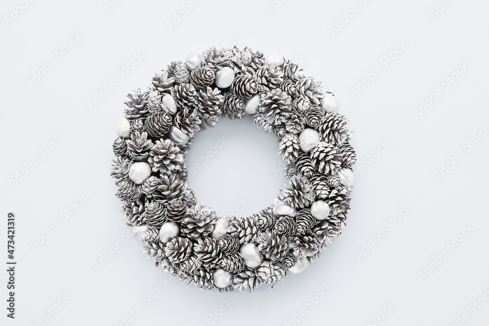 Obraz premium Christmas background. Christmas silver wreath on a light grey background. Copy space, top view.