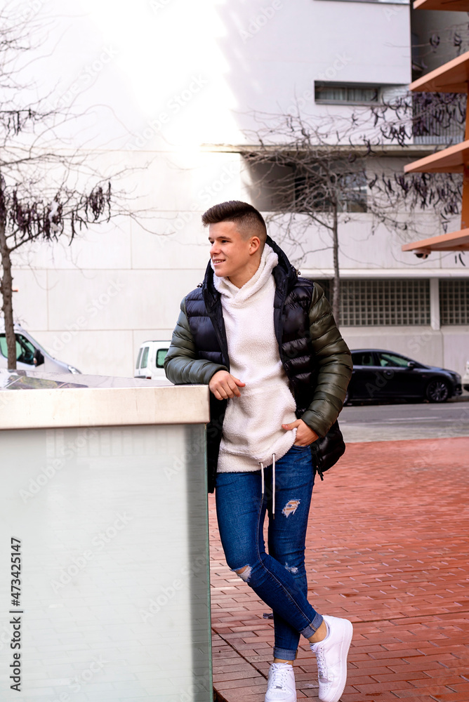 Stylish guy standing on the street hand in pocket looking away
