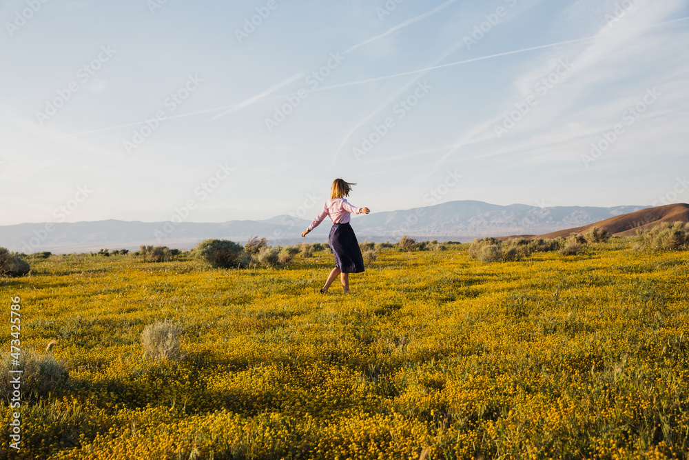Joyful young female dancing in the desert flower field Joyful young female dancing in the desert flower field