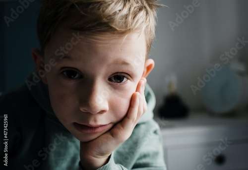 8 year old boy looking tired, thoughtful and expressive at home