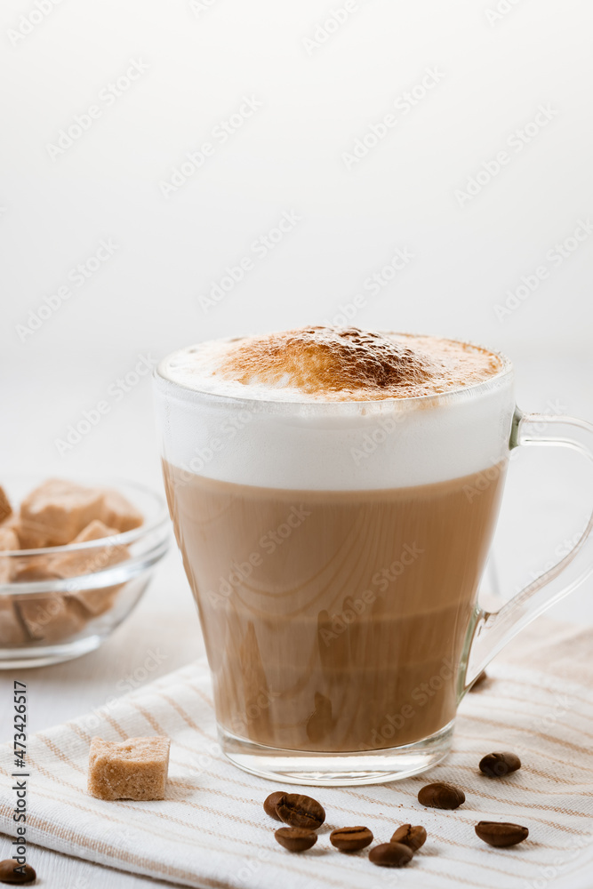 Latte coffee poured in layers with froth and a crispy chocolate top on a light kitchen table. Vertical image with copy space Latte coffee poured in layers with froth and a crispy chocolate top on a light kitchen table. Vertical image with copy space