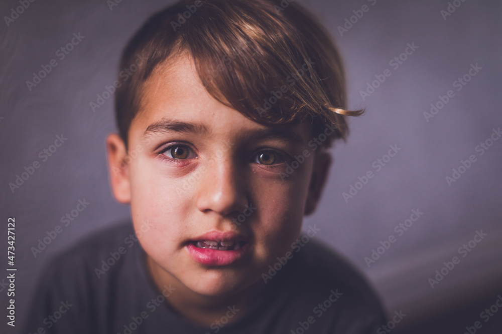 Boy with hazel eyes looking at the camera with an enigmatic look. Boy with hazel eyes looking at the camera with an enigmatic look.