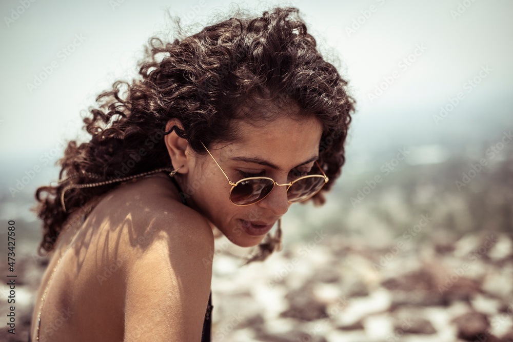 Strong attractive young Mexican woman with curly hair and sun glasses Strong attractive young Mexican woman with curly hair and sun glasses