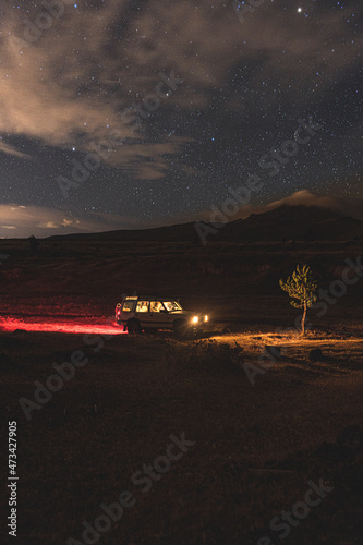 Withe car in the night with mountains and lights photo