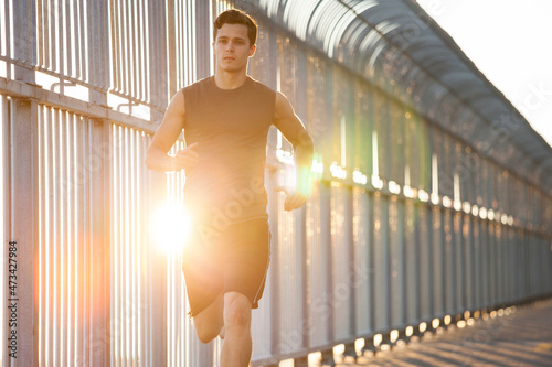 Young man running on bike path in urban city setting photo