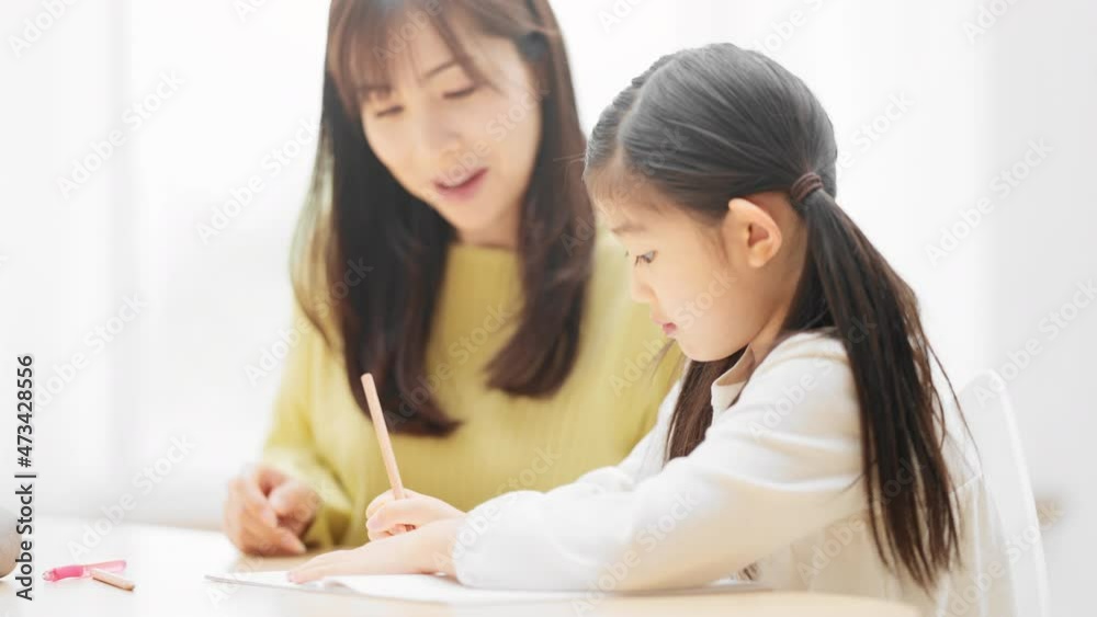 母親に勉強を教えてもらっている娘