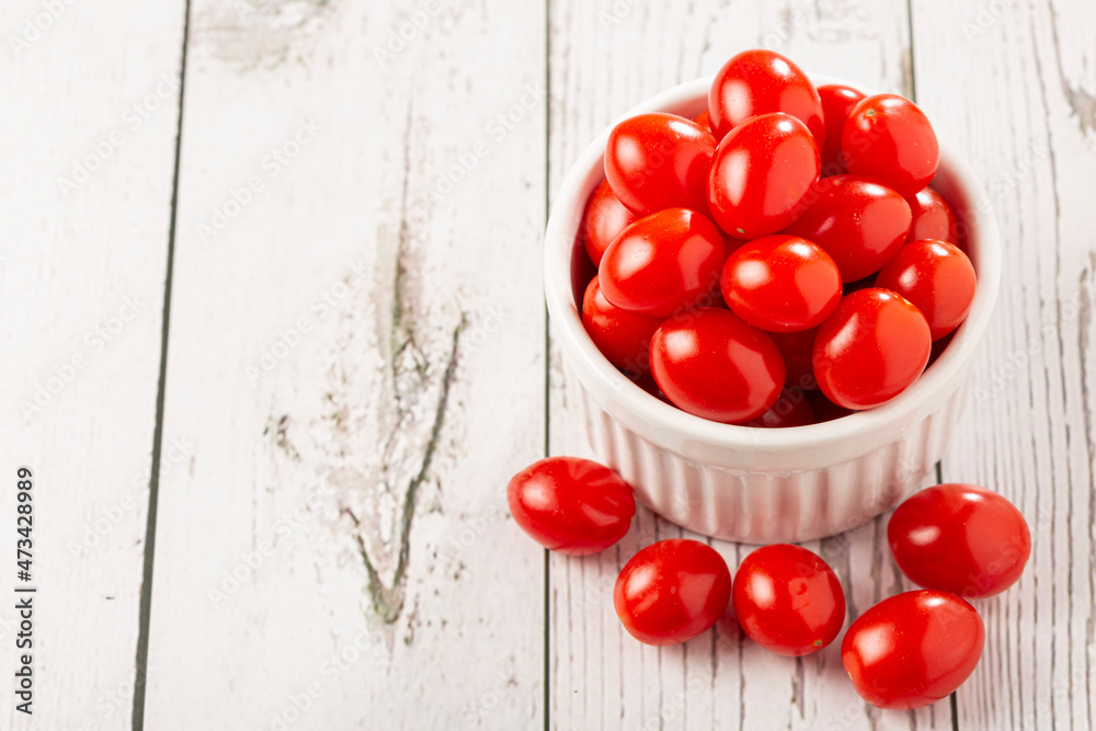 Fresh grape tomatoes in a bowl on the table.