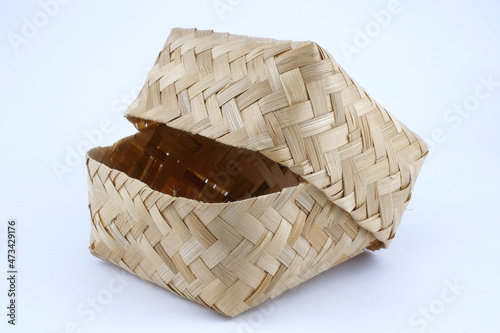 Indonesian traditional container called besek on white isolated background. Besek is a container made of woven bamboo with a rectangular shaped lid to put food, etc. photo