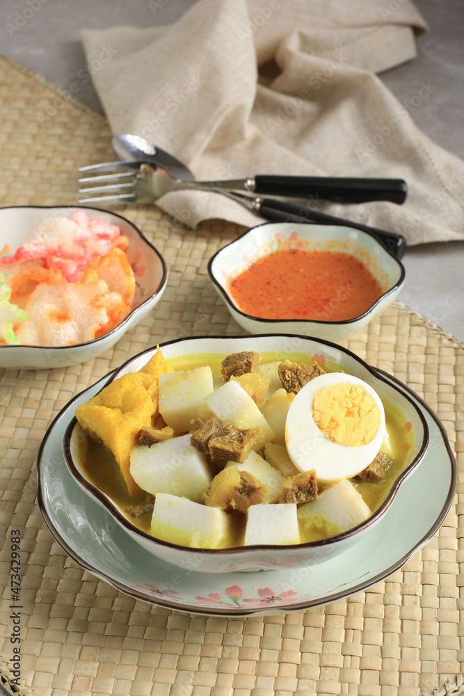 Indonesian Traditional Cuisine: Lontong Kari Sapi, Rice Cake or Ketupat Served with Beef Curry Soup Made from Beef Stock and Light Coconut Milk, Various Spice and Indonesian Herbs