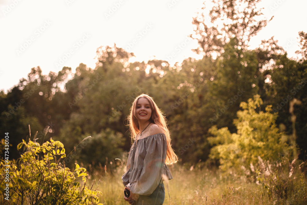 Happy teenage girl with camera standing in summer forest Happy teenage girl with camera standing in summer forest