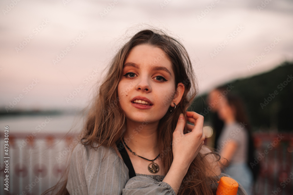 Portrait of teenage girl standing on bridge at sunset during summer Portrait of teenage girl standing on bridge at sunset during summer