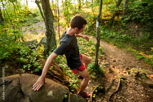 Adult male trail runner on a mountain ridge at golden hour photo