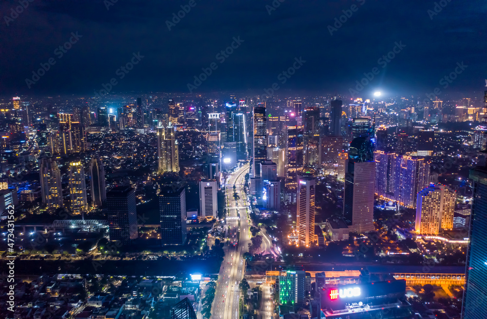 Aerial night cityscape of skyscrapers and multi lane highway traffic in modern city center of Jakarta, Indonesia Urban city center with high rise buildings at night Aerial night cityscape of skyscrapers and multi lane highway traffic in modern city center of Jakarta, Indonesia Urban city center with high rise buildings at night