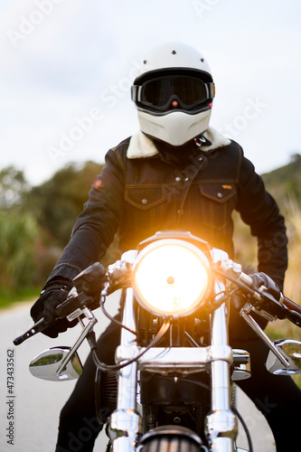 Low angle view of a motorcycle stands on the road with its owner alone photo