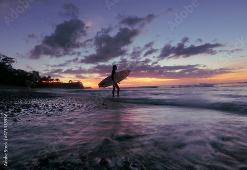 Surfer Girl Silhouette Against Colorful Sunset photo