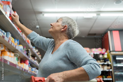 Caucasian senior adult woman shopping inside a supermarket photo