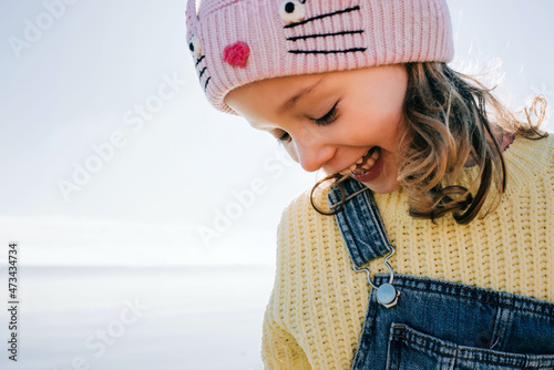 candid portrait of a child laughing at the beach in the sunshine in UK photo