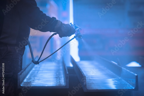 Man with gloves  painting and lacquering steel with compressor photo