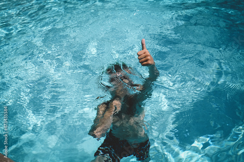 Boy Gives a Thumbs up While Holding Breath Underwater