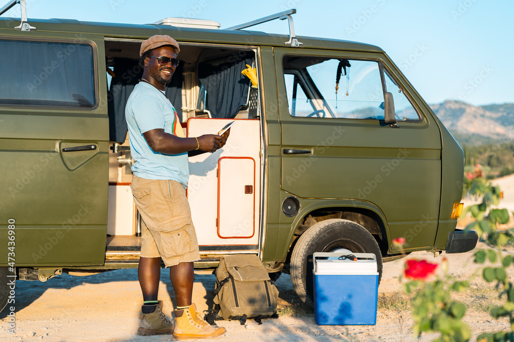 black man with glasses, and mobile phone in camper van black man with glasses, and mobile phone in camper van