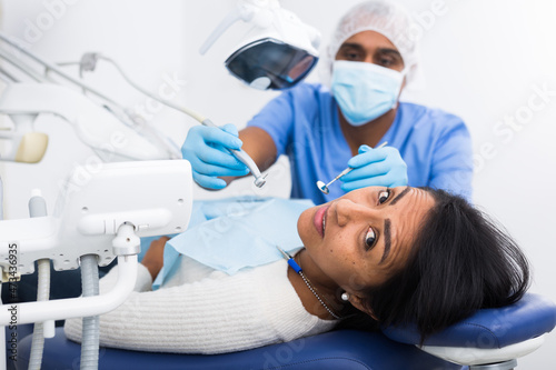 Dentist male in uniform is examinating of female in dental clinic photo