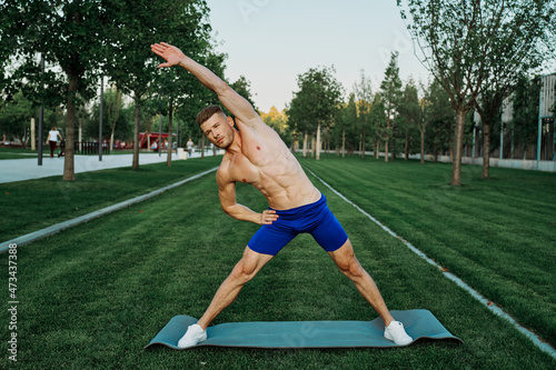sports muscular man doing fitness crossfit in the park
