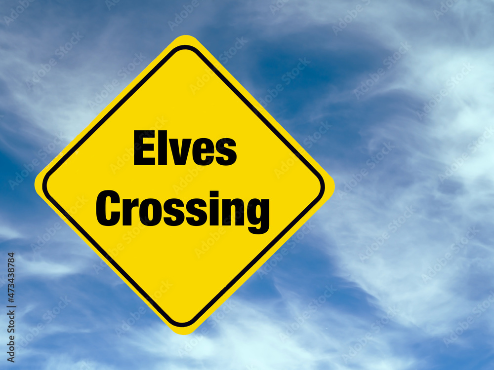 Yellow diamond shaped road warning sign with a Christmas theme concept. Elves Crossing text. Yellow diamond shaped road warning sign with a Christmas theme concept. Elves Crossing text.